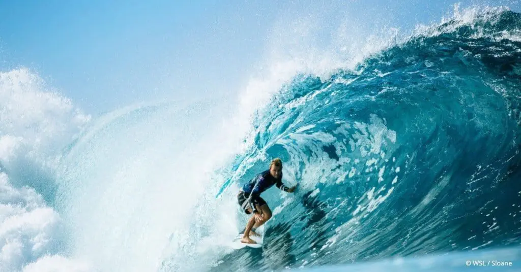 Surfer riding inside a large barrel wave