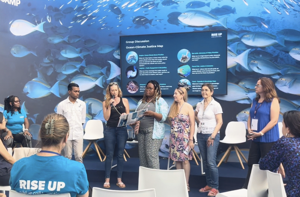 Group of young people presenting on stage in front of an underwater-themed screen.