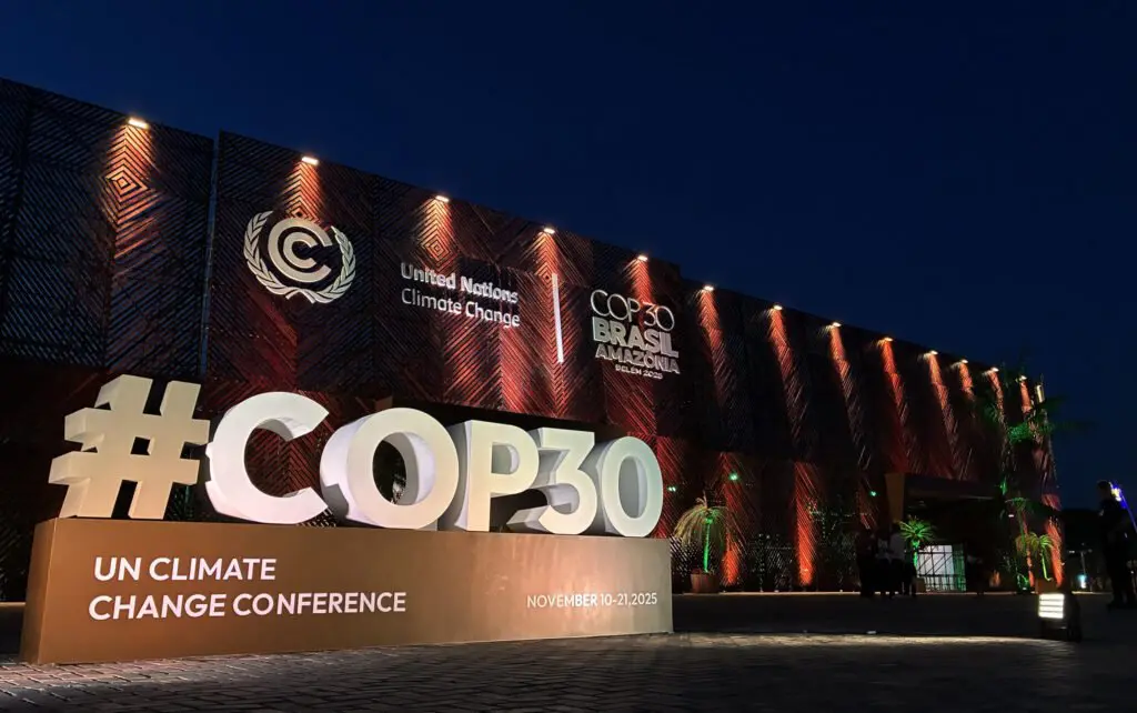 Illuminated #COP30 signage outside the conference venue at night