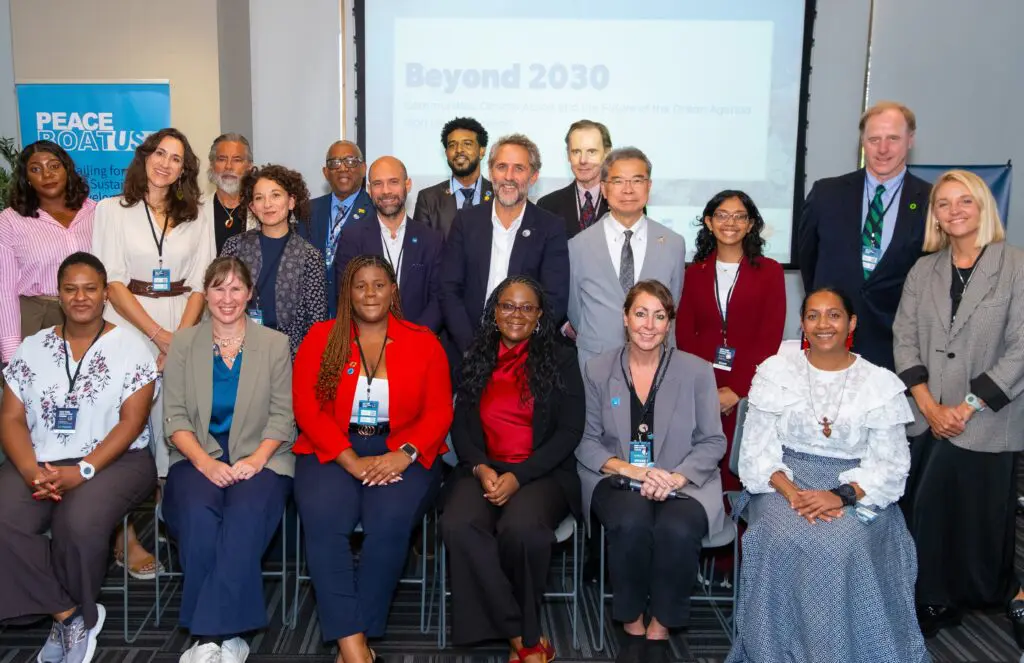 Group photo of speakers and participants at the Beyond 2030 High-Level Luncheon, co-hosted by RISE UP and Peace Boat US, in front of the event's title slide